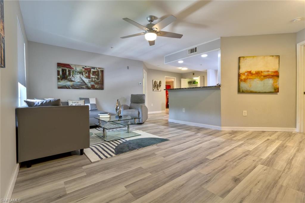 Living room with ceiling fan and light wood-type flooring