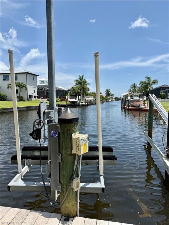 Waterfront property featuring a boat lift, canal access, and a wooden dock