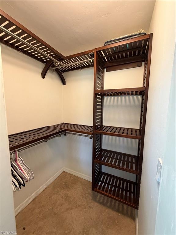 Custom closet system featuring dark wood-finish shelving and chrome hanging rods