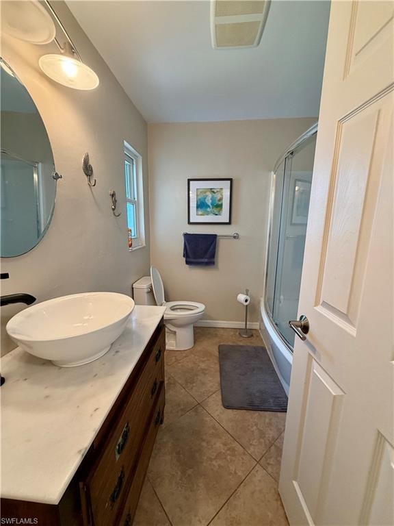 Bathroom featuring a vessel sink atop a marble-finish countertop and wood-finish vanity