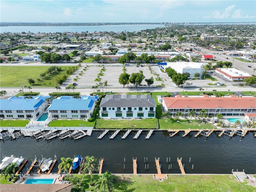 Waterfront property with multiple boat docks, a private swimming pool, and a manicured lawn