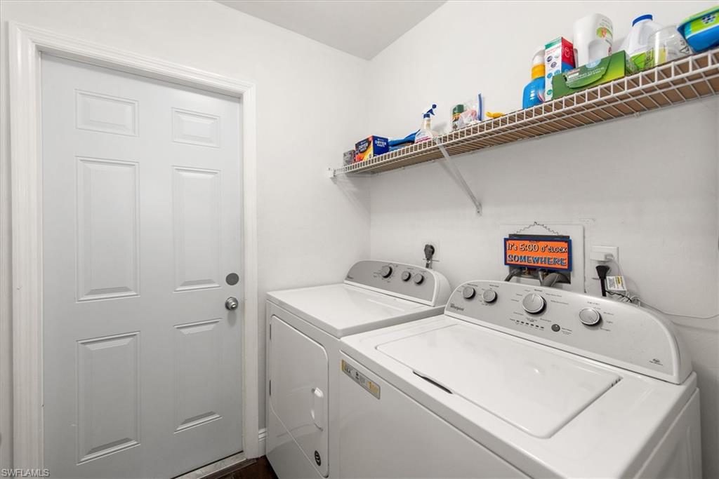 Dedicated laundry area featuring a white six-panel door, white walls, and built-in wire shelving