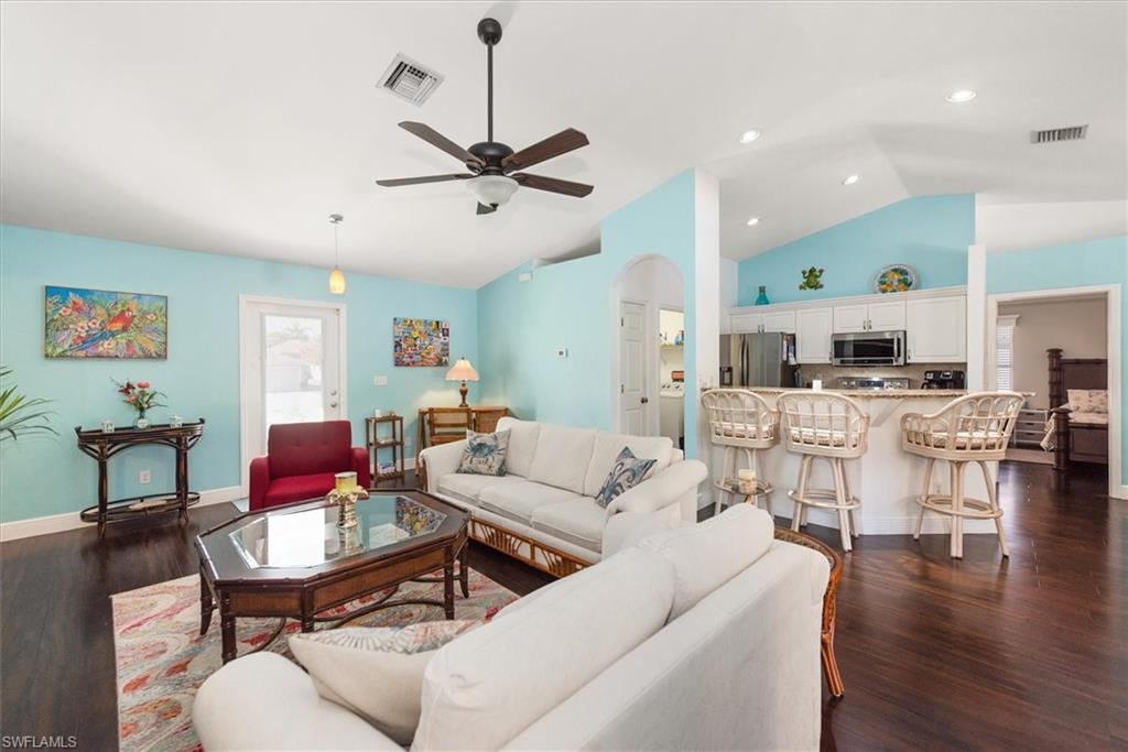 Open-concept living area with vaulted ceilings and wood-finish flooring