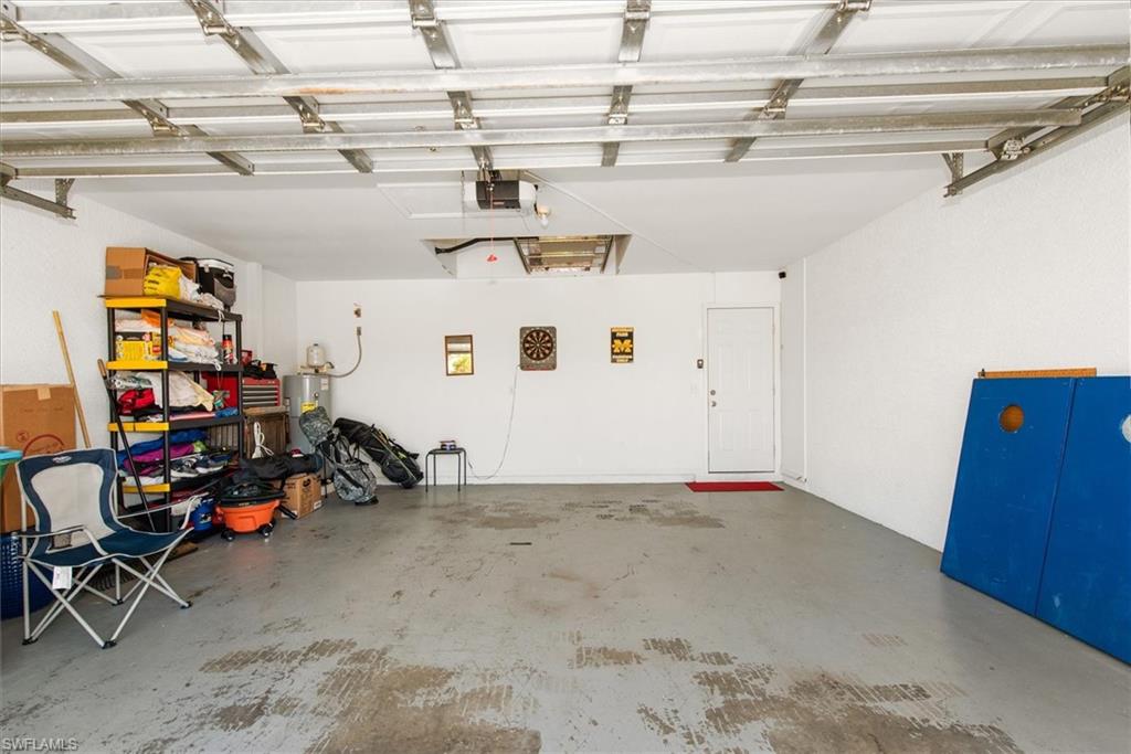 Spacious garage featuring a concrete floor, painted white walls, and an overhead garage door mechanism
