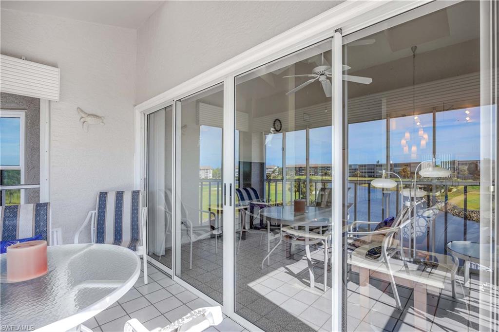 Balcony featuring outdoor dining space, ceiling fan, a water view, and a sunroom