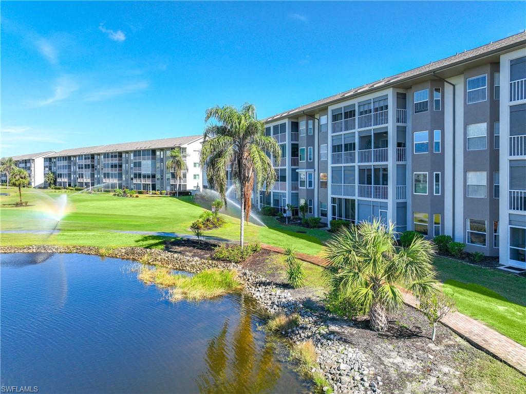 View of community with a yard, a water view, and golf course view