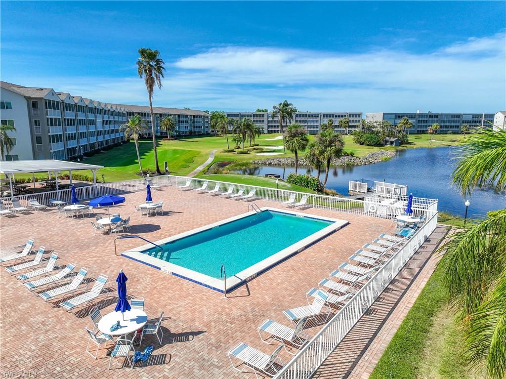 Community pool featuring a water view, view of golf course, and a patio area