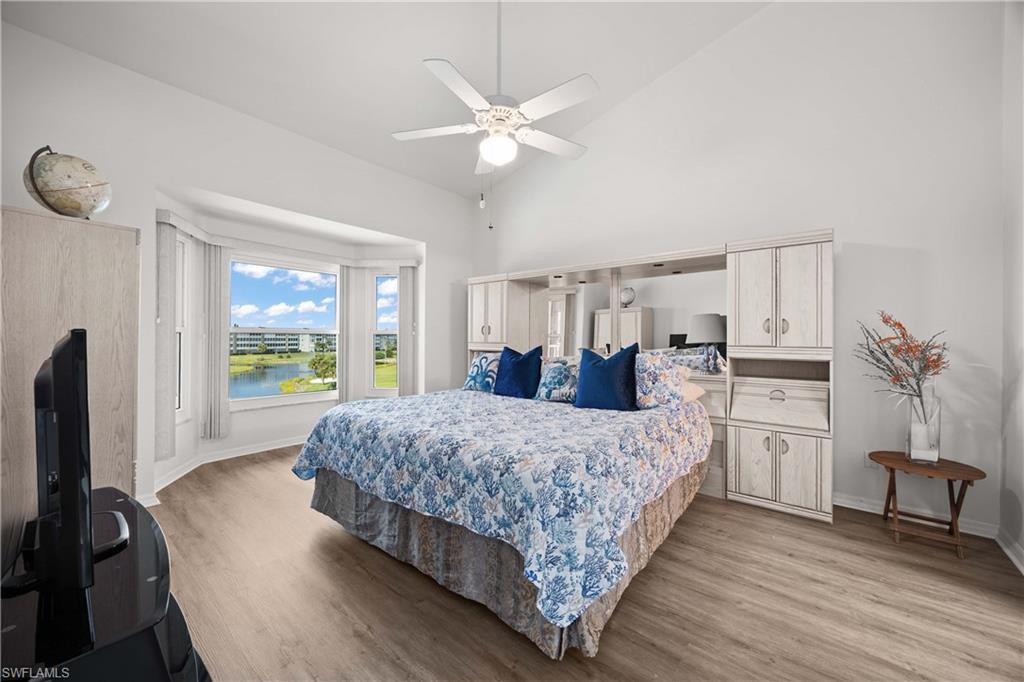 Bedroom featuring high vaulted ceiling, light wood-type flooring, and a ceiling fan