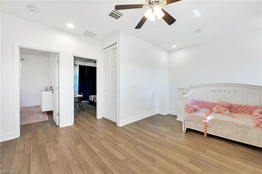 Room featuring wood-finish flooring, recessed lighting, a ceiling fan, and white baseboards