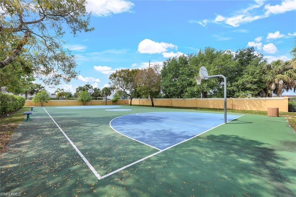 Multi-sport court featuring a painted surface with blue and green sections, white line markings, and two basketball hoops