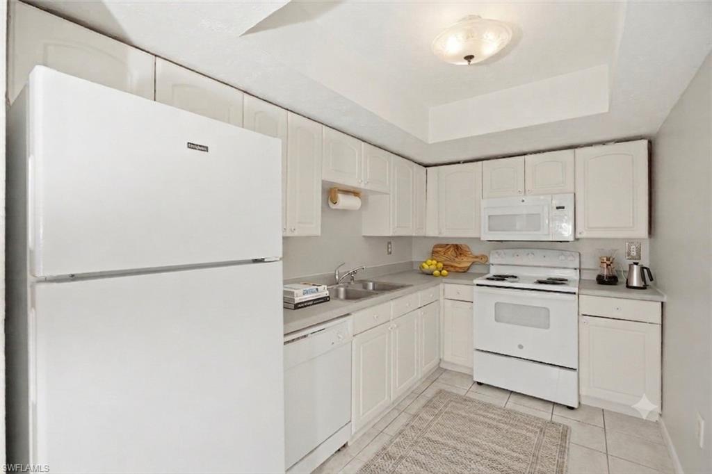 Kitchen showing white cabinetry and white appliances.