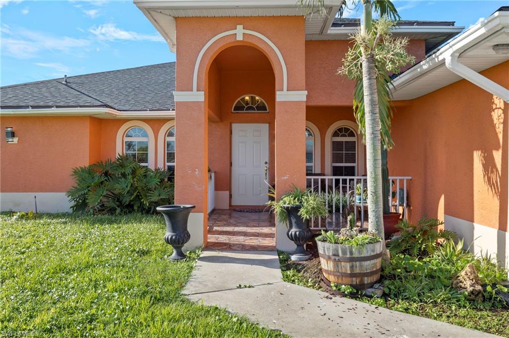 Mediterranean-inspired exterior with an arched entry, a covered front porch, and decorative arched windows