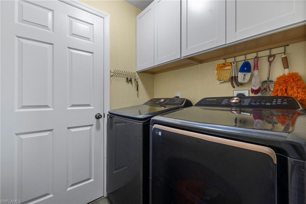 Dedicated laundry area featuring a six-panel door, light yellow wall color, and white upper cabinetry