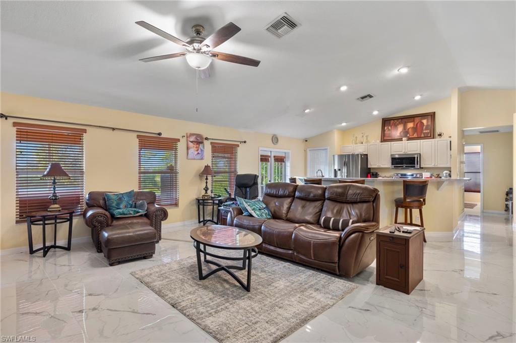 Open-concept living space featuring high vaulted ceilings, recessed lighting, a ceiling fan, and large format Porcelain tile flooring