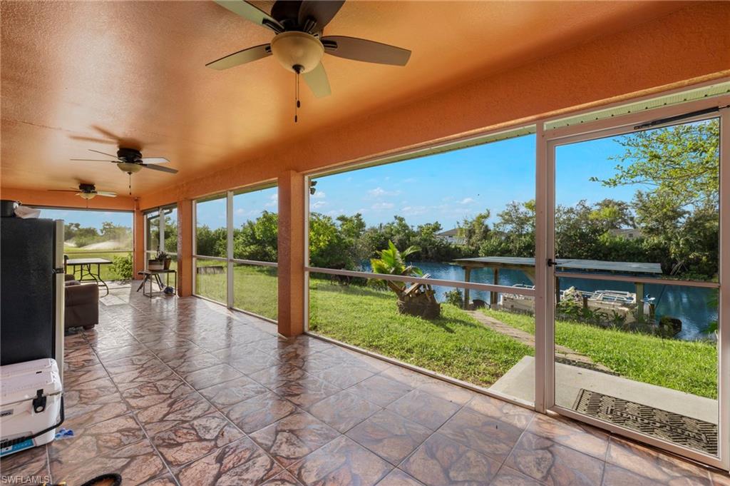 Screened lanai featuring patterned tile flooring and ceiling fans