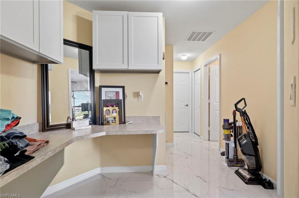 Hallway featuring light-toned walls and polished tile flooring