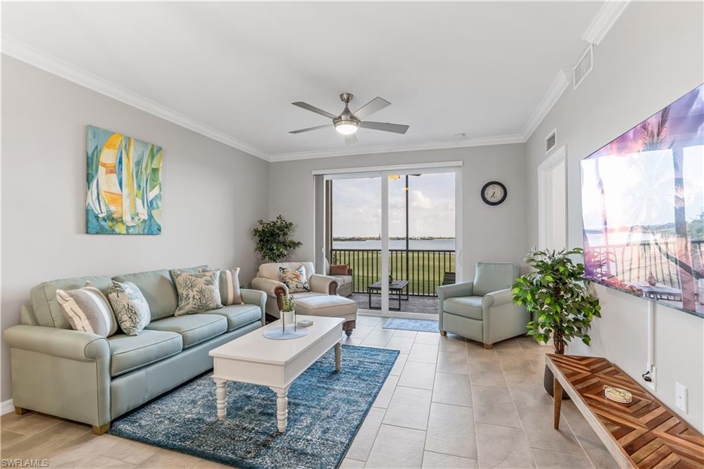 Living room with ceiling fan, light tile floors, and crown molding