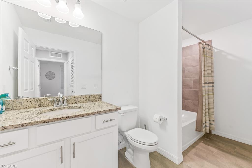 Full bathroom with vanity, toilet, tile floors, and shower / tub combo