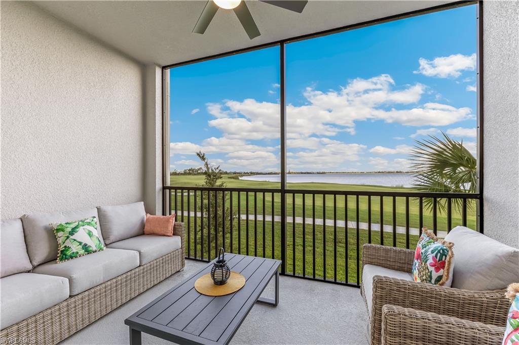 Sunroom / solarium featuring ceiling fan and a water view