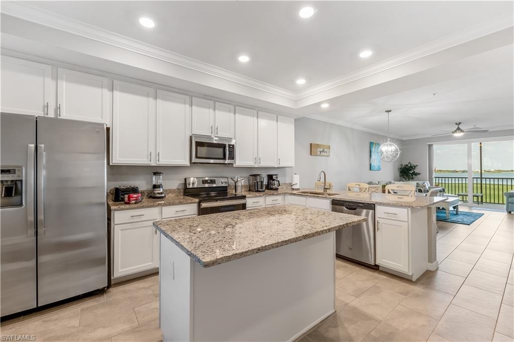 Kitchen featuring appliances with stainless steel finishes, sink, kitchen peninsula, and light stone counters