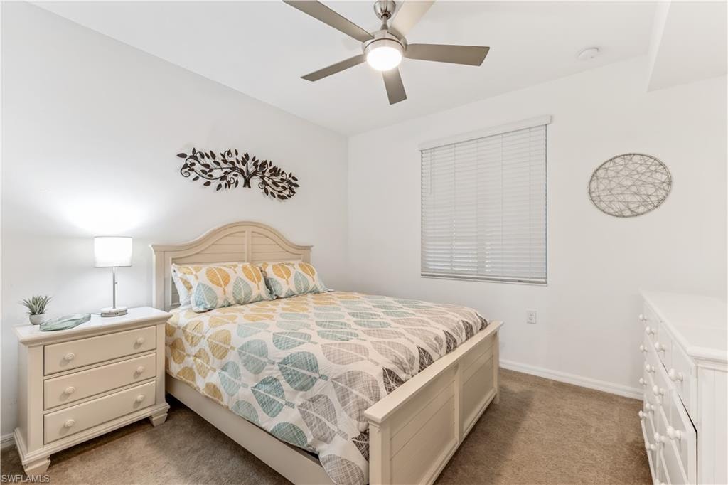 Carpeted bedroom featuring ceiling fan