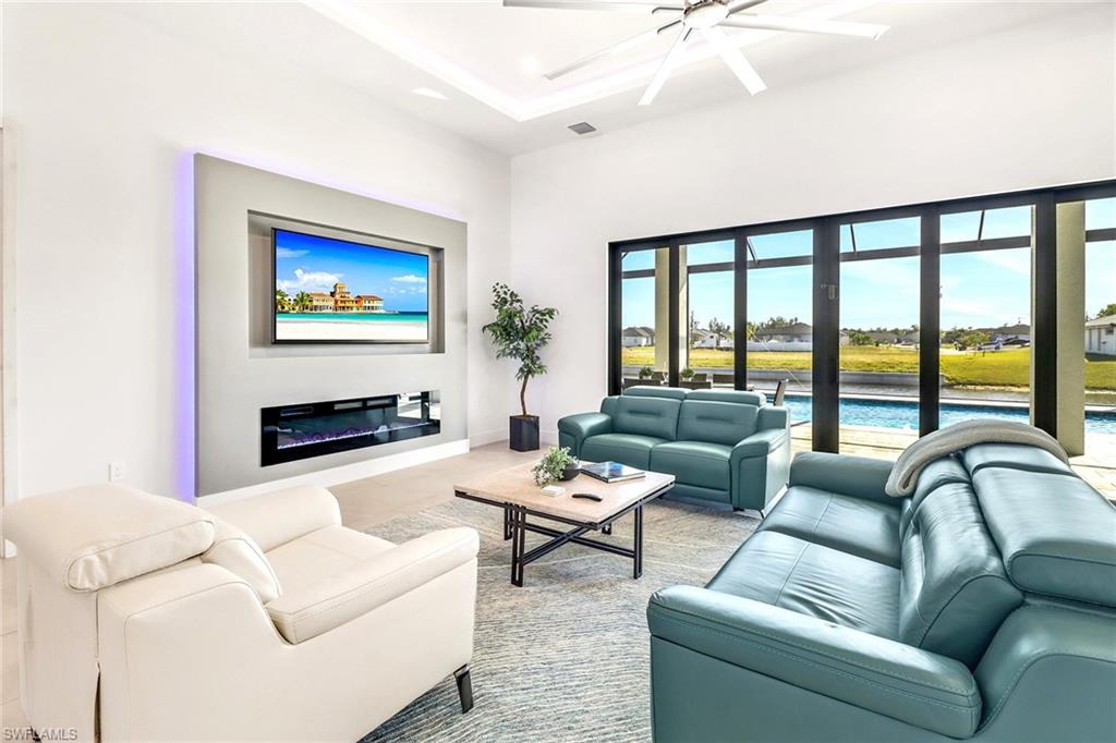 Living area featuring a contemporary built-in media wall with integrated electric fireplace and backlighting