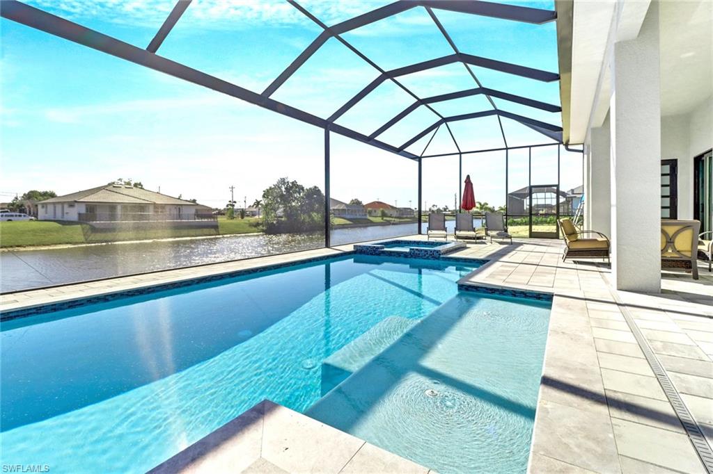 Screened lanai featuring a swimming pool, integrated spa, and expansive patio