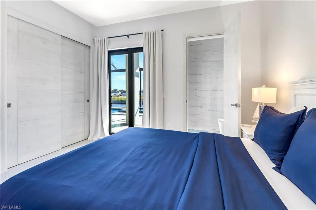 Bedroom featuring a sliding glass door leading to an outdoor area, white sliding closet doors, white paneled headboard, and wood-finish flooring