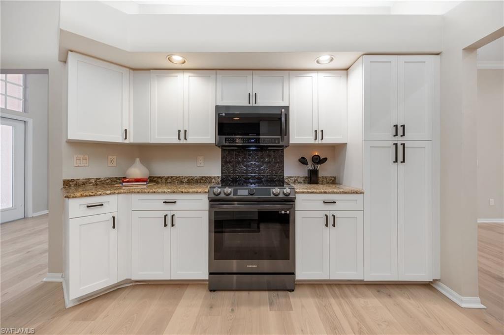 Slide in self cleaning stove and microwave. View of access to front entrance from the Kitchen on left. Such great storage in this kitchen!