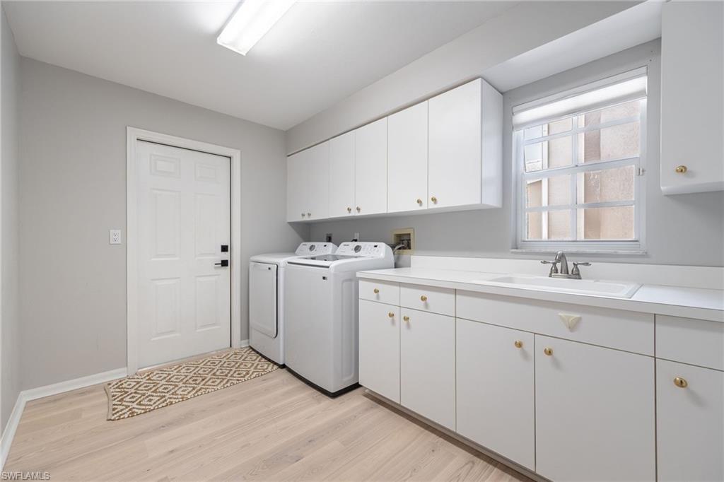 Laundry room with abundance of cabinets. This could be your extra pantry space! Utillity sink and counter tops to fold clothes or work on projects.