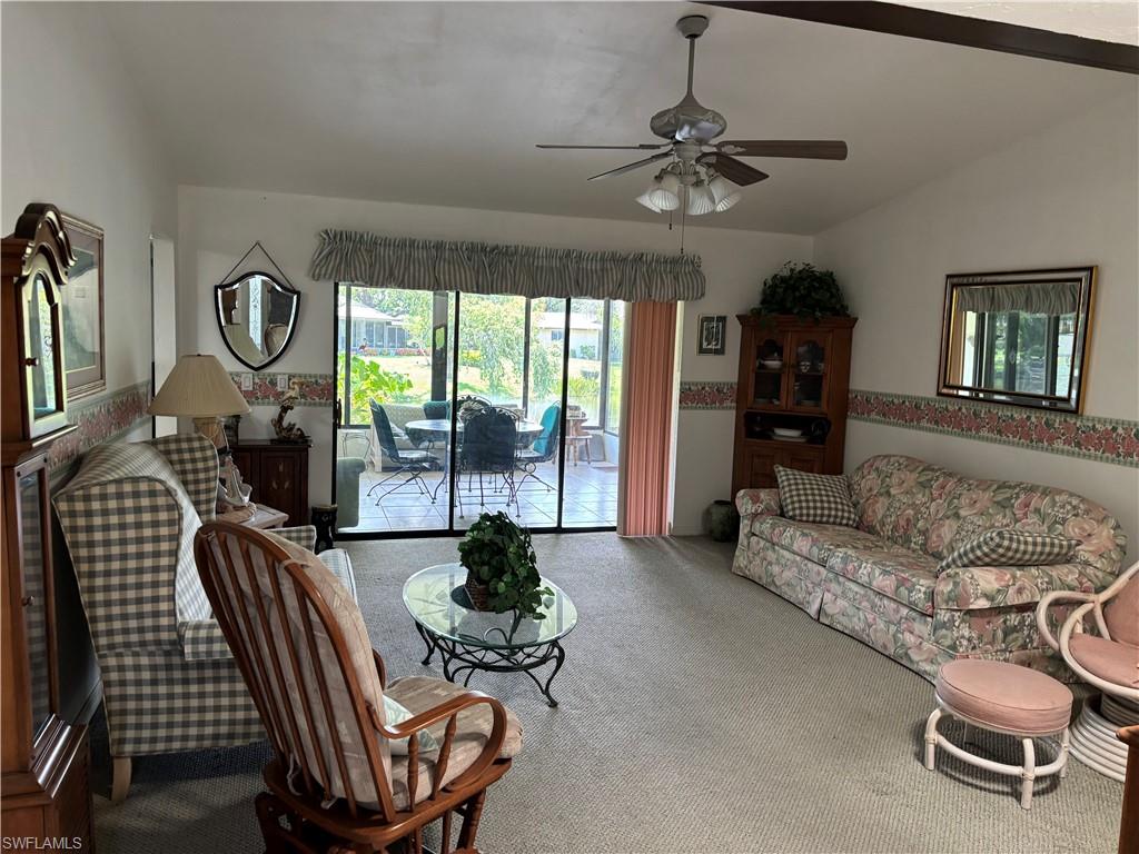 Carpeted living space featuring a sliding glass door to an outdoor patio with tiled flooring