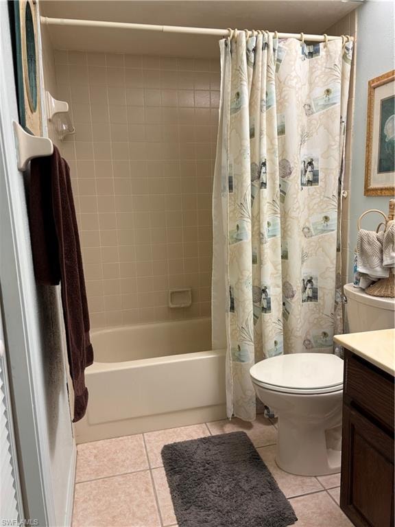 Bathroom featuring a combination shower and tub with neutral-toned wall tiling, a white toilet, and a dark wood-finish vanity with a light-toned countertop