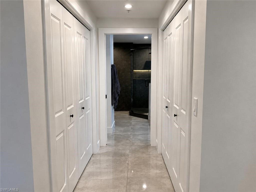 Hallway featuring light-toned tile flooring and recessed lighting