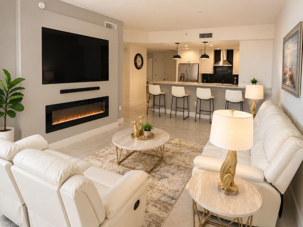 Open-concept living area featuring an integrated media wall with a mounted television and linear electric fireplace