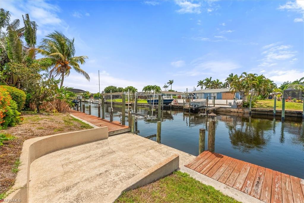 Dock with a water view, boat lift, and a residential view