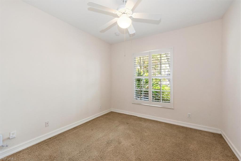 Carpeted spare room featuring baseboards and ceiling fan