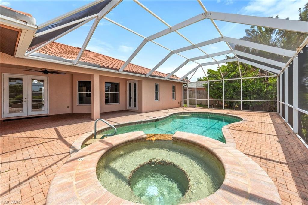 View of pool featuring a pool with connected hot tub, a patio area, french doors, and ceiling fan