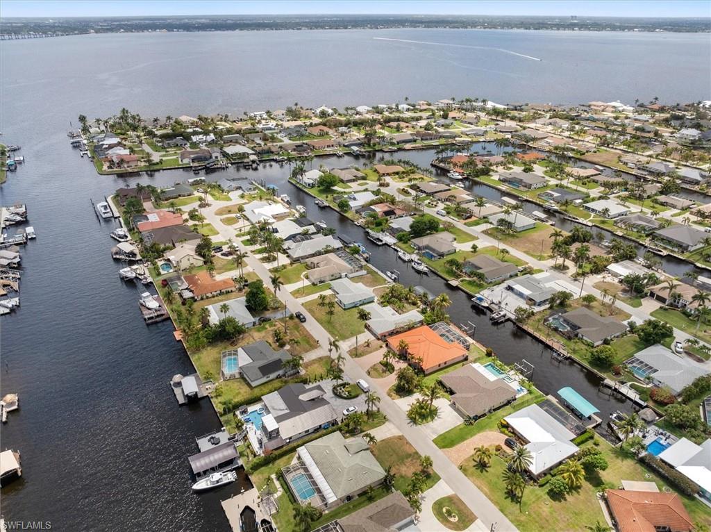 Aerial view of property and surrounding area with nearby suburban area and a large body of water