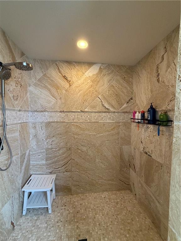 Huge Walk-in shower featuring large format natural stone wall tiles, a mosaic tile floor, and a recessed ceiling light