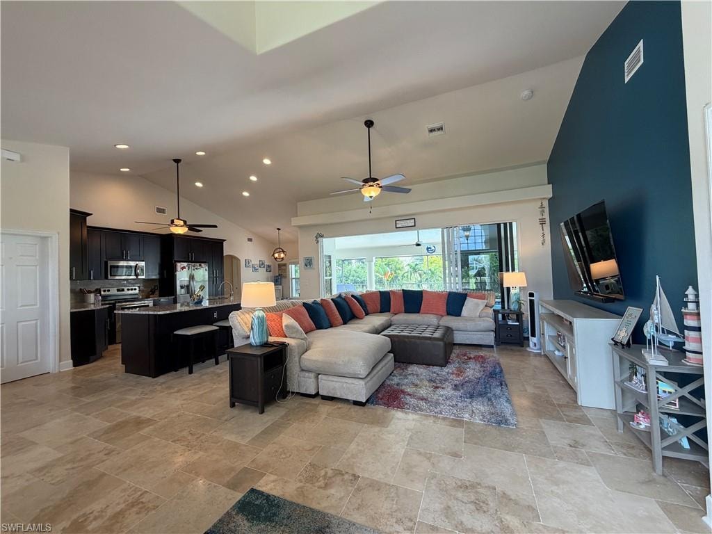 Open-concept living area with vaulted ceilings and recessed lighting