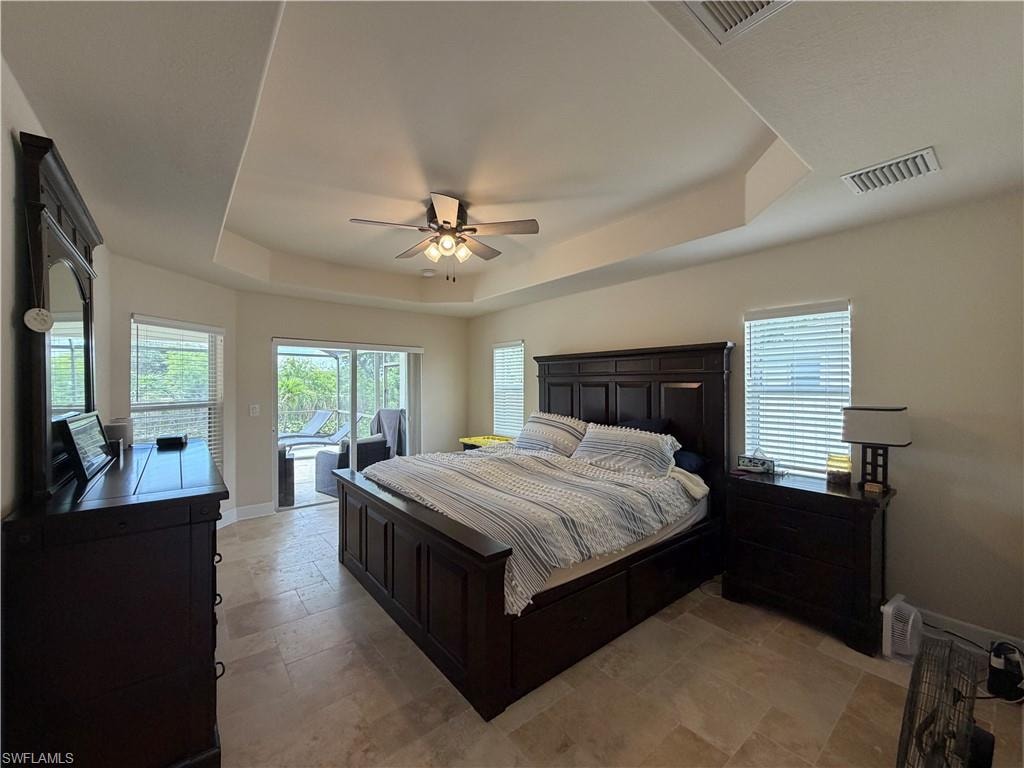 Room featuring tray ceilings and travertine pool decking