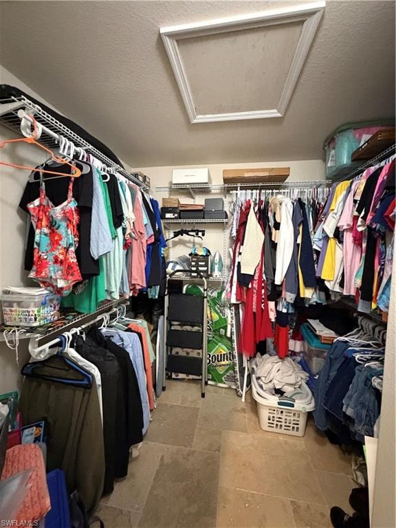Walk-in closet featuring travertine tile flooring and white wire shelving systems
