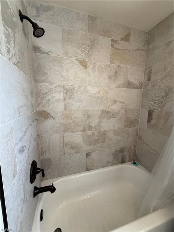 Hallway Bathtub/Shower Combo with light-toned, rectangular wall tiling