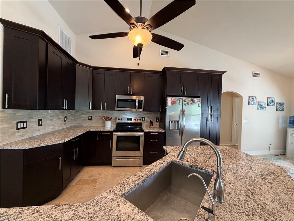 Kitchen featuring dark wood cabinetry, granite countertops, and stainless steel appliances