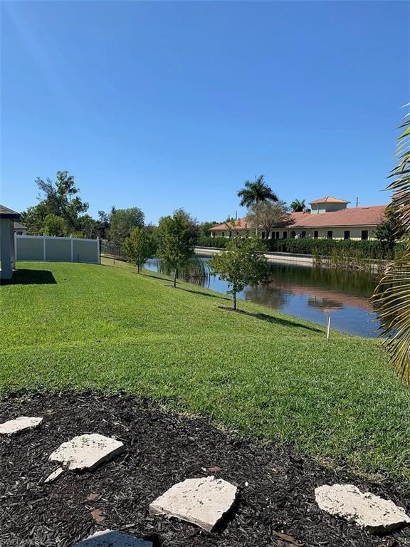 Expansive backyard featuring a lush lawn, stepping stones, and a tranquil canal