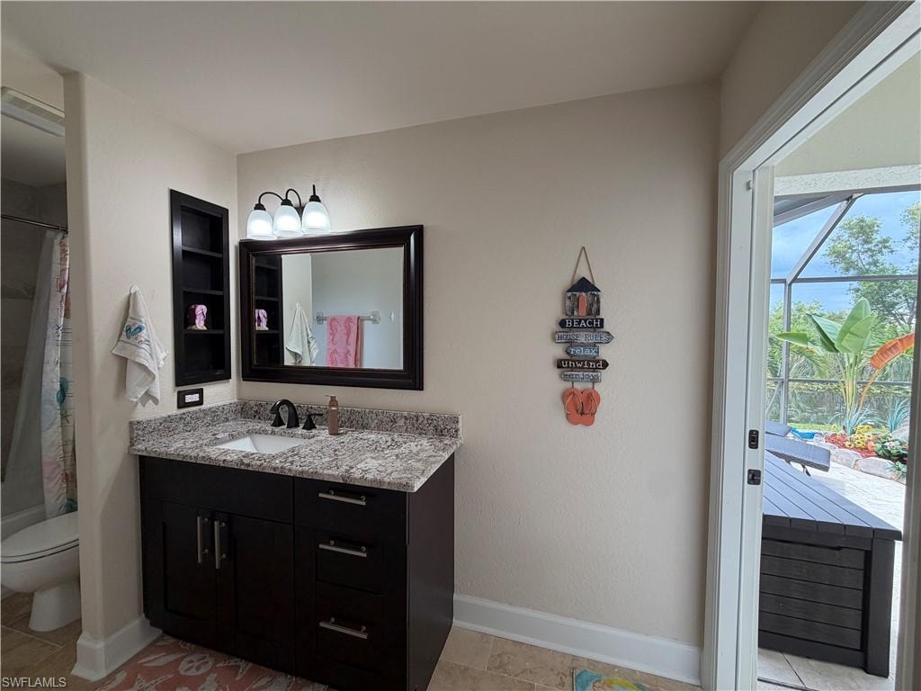 Hallway Bathroom featuring a dark wood-finish vanity with granite countertop, an undermount sink, and a black faucet