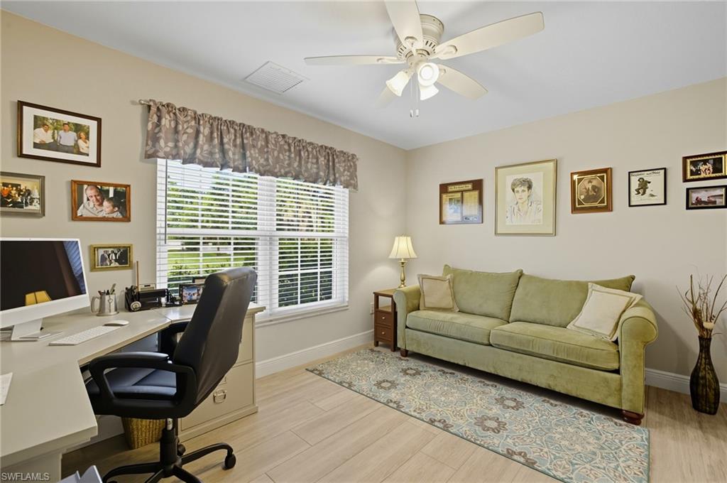 Room featuring a window with horizontal blinds, light wood-finish flooring, and a ceiling fan