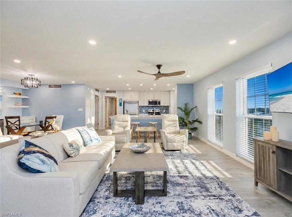 Living area with a ceiling fan, light wood-style floors, and recessed lighting