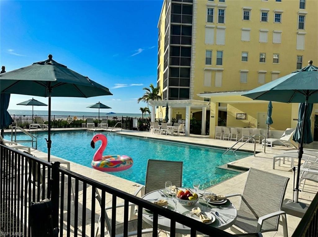 Community pool featuring outdoor dining space and a patio