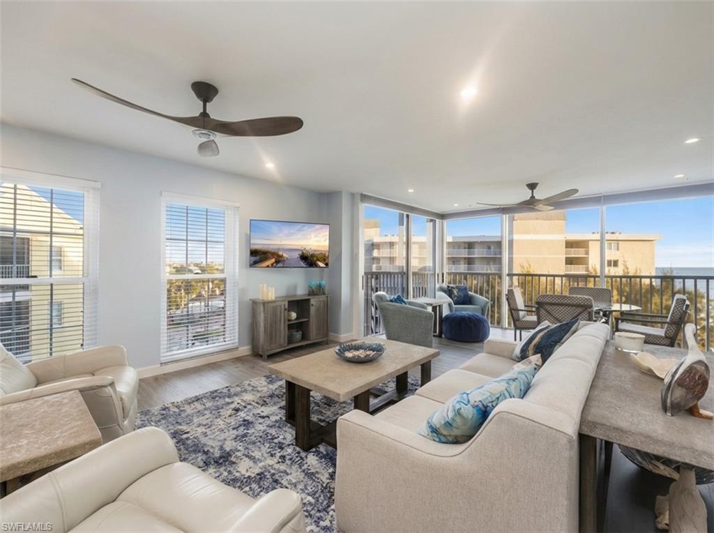 Living room with ceiling fan, wood finished floors, healthy amount of natural light, and recessed lighting